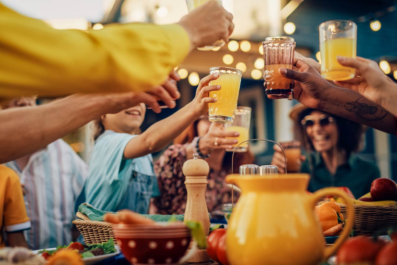 multicultural family and friends gathering together at a backyard party