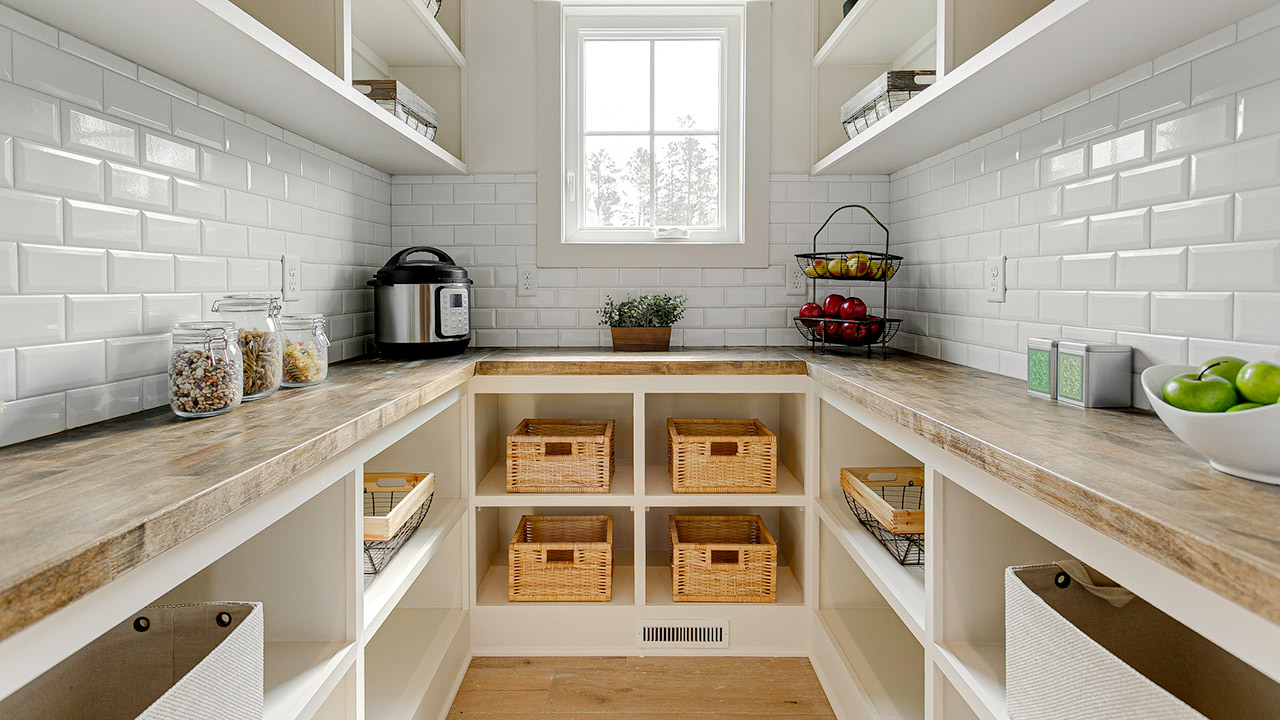 An organized pantry featuring wooden shelves and storage baskets, providing ample space for kitchen essentials