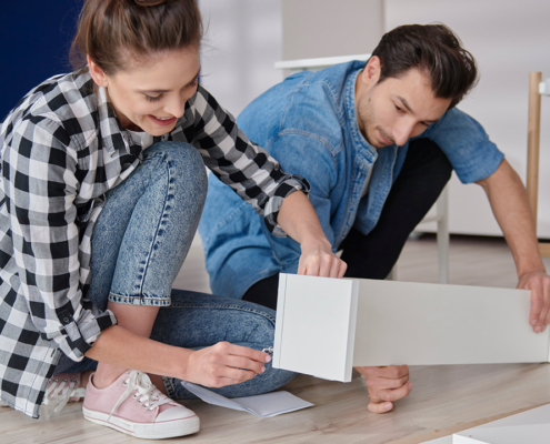 couple installing bookshelf for new house stock photo