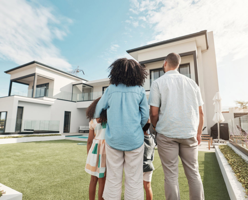 new house and family in their backyard together looking at their property