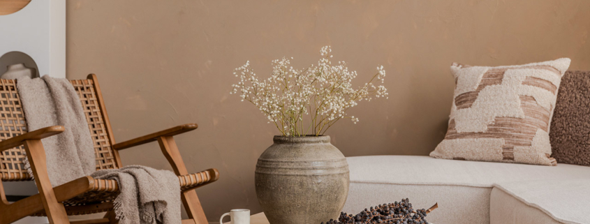 Natural-toned interior with rustic vase, textured pillows, and cozy lounge chair in a calm neutral setting stock photo
