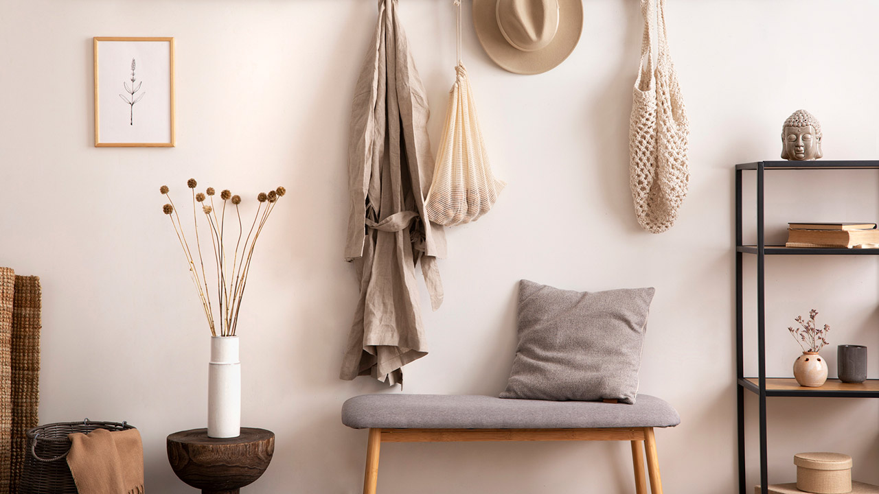 Cosy entryway with grey bench, coffee table, hanger and personal accessories stock photo