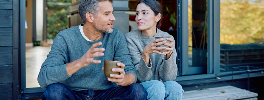 Couple relaxing and enjoying coffee while talking outdoors stock photo